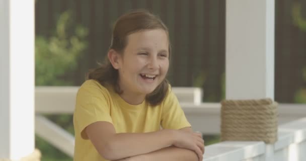 Smích a usmívající se portrét mladé dívky, která se dívá na kameru na bílém Terrasse - Záběry, video