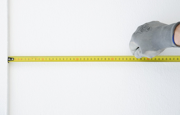 Hand in protective gloves with Metre measure ruler - 写真・画像