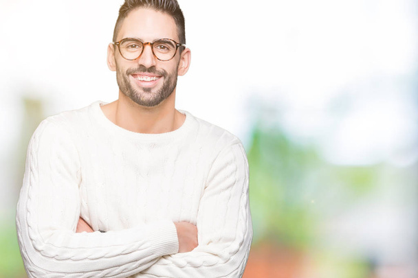 Young handsome man wearing glasses over isolated background happy face smiling with crossed arms looking at the camera. Positive person. - Foto, imagen
