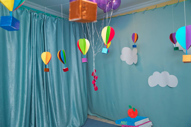 Hanging from above Colorful paper balloon with blue sky background and clouds. Origami made colorful air balloon cloud. - Фото, изображение
