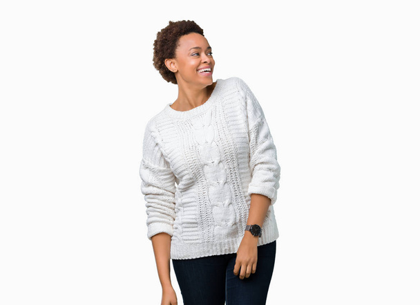 Όμορφη νεαρή αφρικανική αμερικανική γυναίκα που φορώντας πουλόβερ πέρα από το απομονωμένο υπόβαθρο κοιτάζοντας μακριά πλευρά με χαμόγελο στο πρόσωπο, φυσική έκφραση. Γελώντας αυτοπεποίθηση. - Φωτογραφία, εικόνα