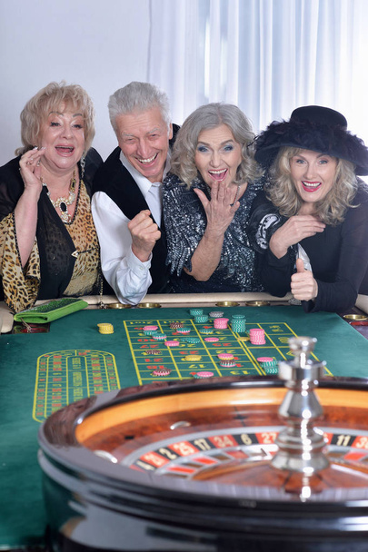senior people playing in casino, spending time together  - Фото, зображення