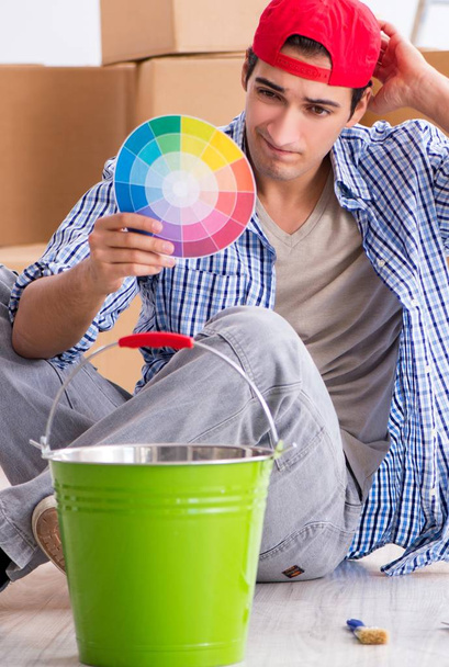 Молодой художник подрядчик выбирает цвета для ремонта дома - Фото, изображение