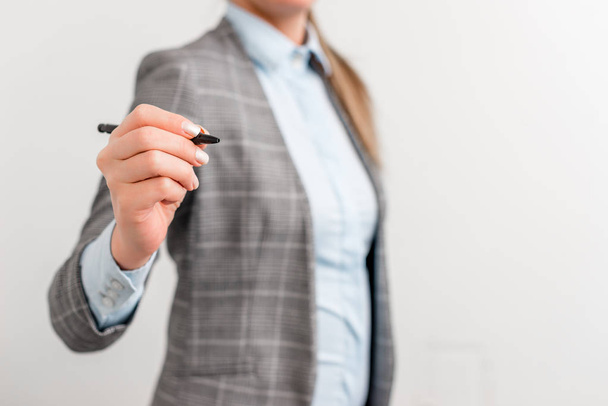 Business woman pointing in empty space with pen. Business concept image with business woman holds pencil. - Photo, Image
