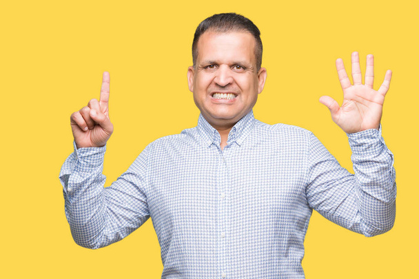 Арабський бізнесмен середнього віку над ізольованим тлом, показуючи і вказуючи пальцями номер шість, посміхаючись впевнено і щасливо
. - Фото, зображення