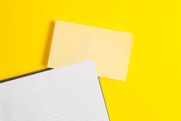 Empty orange paper with copy space on the yellow table. Blank paper for text messages. Business concept with blank papers on the table. - 写真・画像