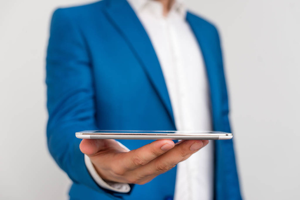 Чоловік у синьому номері і біла сорочка тримає мобільний телефон в руці. Бізнес-концепція з бізнесменом і мобільним телефоном в руці
. - Фото, зображення