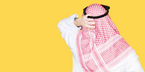 Арабский бизнесмен с длинными волосами, одетый в традиционный шарф Кеффийе задом наперёд, думает о сомнении с рукой на голове.
 - Фото, изображение
