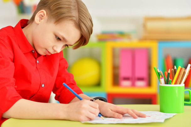 Portrait of cute little boy drawing with pencils - Фото, изображение