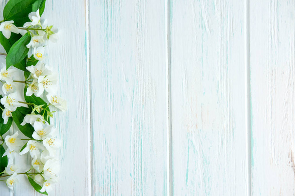 Achtergrond voor felicitatie banner met jasmijn bloemen op houten achtergrond. Jasmijn bloemen op houten achtergrond. Platte lay, bovenaanzicht. - Foto, afbeelding