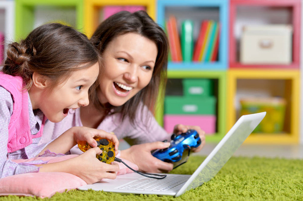  mother and daughter using laptop together playing  game  - Photo, Image