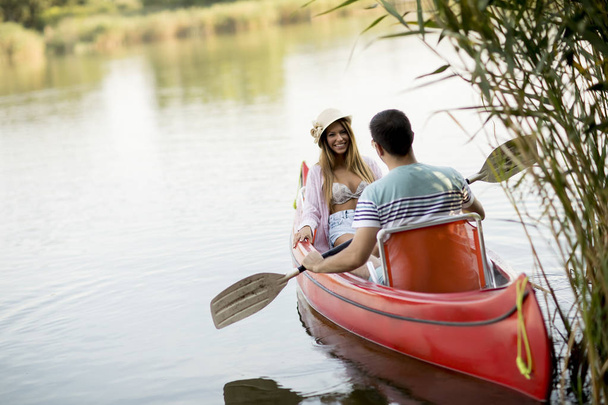 Loving couple rowing on the lake at summer day - Fotoğraf, Görsel