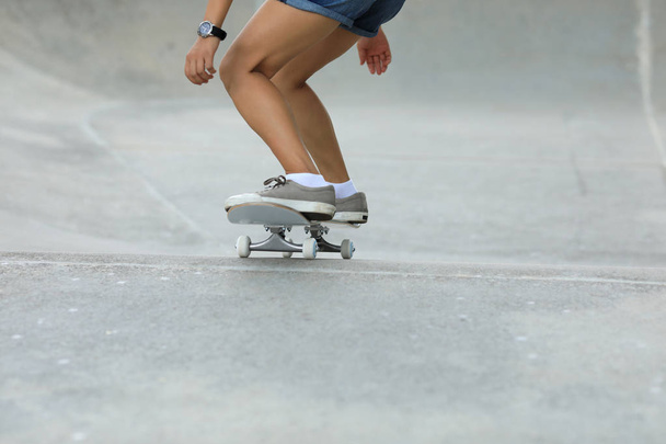 Female skateboarder skateboarding at skatepark in city - Foto, Imagem