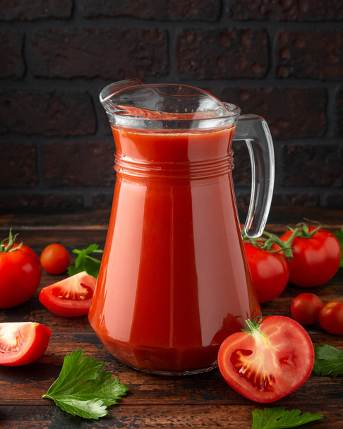 Suco de tomate em jarro de vidro com aipo em mesa de madeira rústica
 - Foto, Imagem