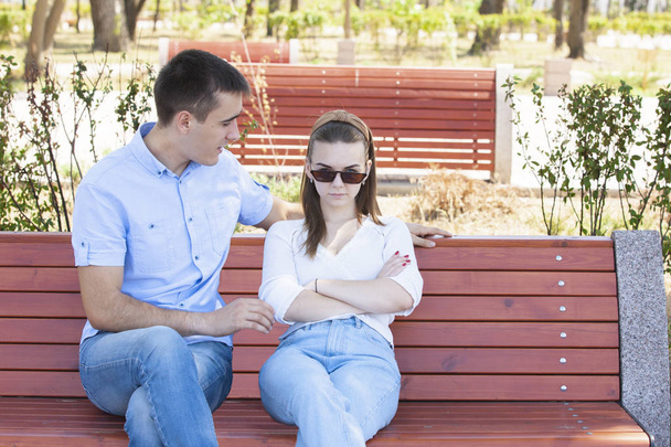 Happy young couple in love sitting on a park bench - Foto, imagen