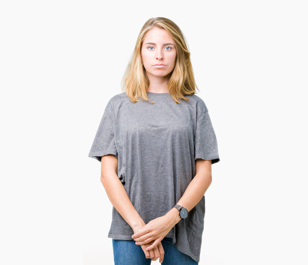 Mooie jonge vrouw oversize casual t-shirt dragen over geïsoleerde achtergrond Relaxed met ernstige uitdrukking op het gezicht. Simpel en natuurlijk kijken naar de camera. - Foto, afbeelding