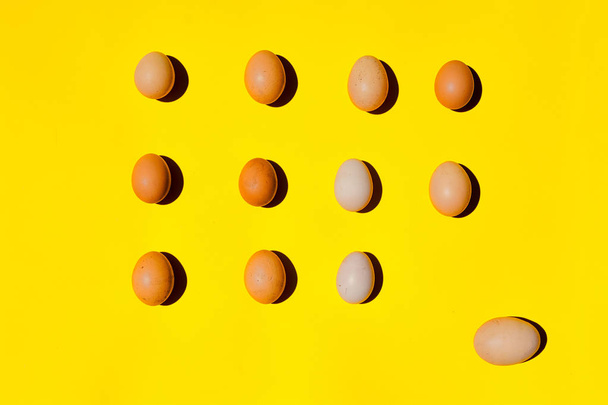 ein Eiermuster. Eier unterschiedlicher Größe auf gelbem Hintergrund. - Foto, Bild