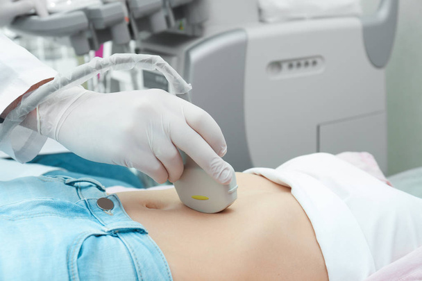 Doctor conducting ultrasound examination of internal organs in clinic, closeup - Foto, imagen
