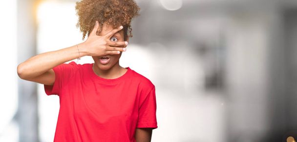 Gyönyörű fiatal afro-amerikai nő felett elszigetelt háttér less a sokkot, amely az arc és a szem-kéz, ujjak zavarban kifejezést keres. - Fotó, kép