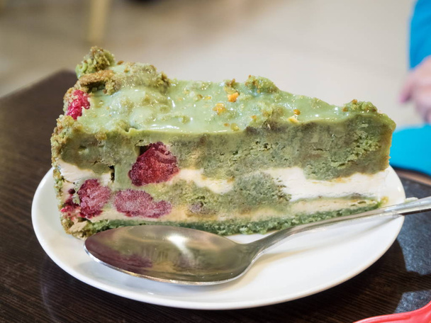 A piece of green cake on a table in a plate - Photo, Image