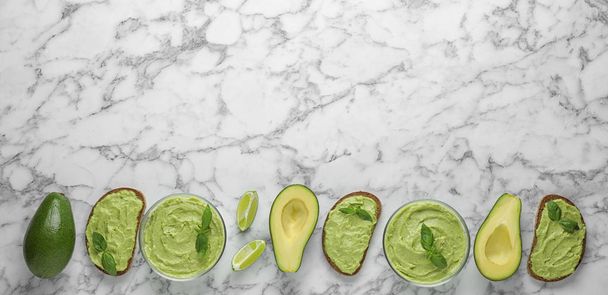 Flat lay composition with guacamole, sandwiches and avocados on white marble table. Space for text - Foto, immagini