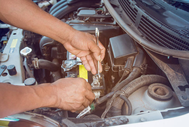 Car mechanic working Install battery with wrench in garage. Repa - Photo, Image
