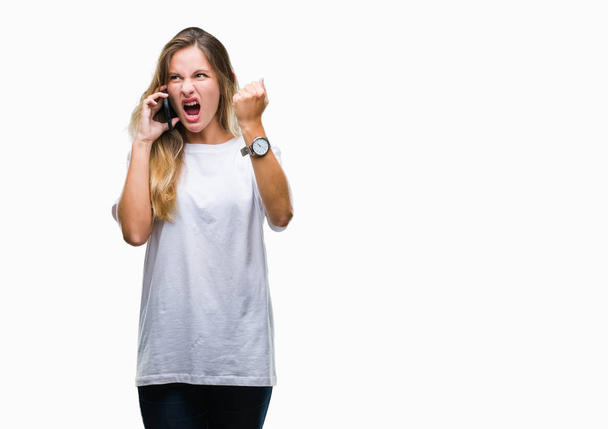 Young beautiful blonde woman calling using smartphone over isolated background annoyed and frustrated shouting with anger, crazy and yelling with raised hand, anger concept - Fotografie, Obrázek