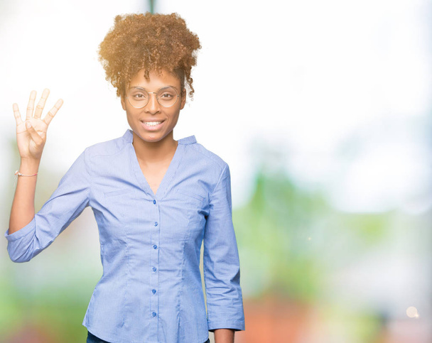 Bella giovane donna d'affari africana americana su sfondo isolato mostrando e indicando con le dita il numero quattro sorridendo fiduciosa e felice
. - Foto, immagini