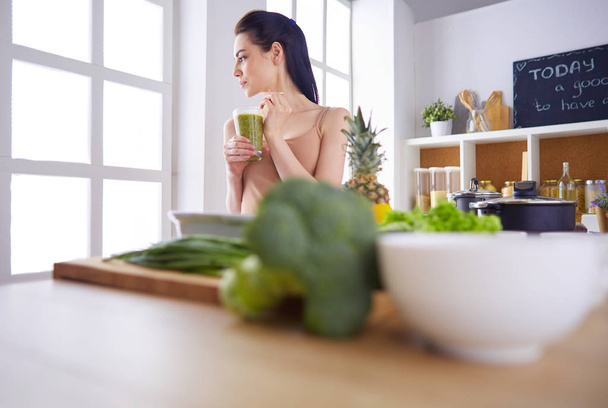 Young woman with glass of tasty healthy smoothie at table in kitchen - Photo, image