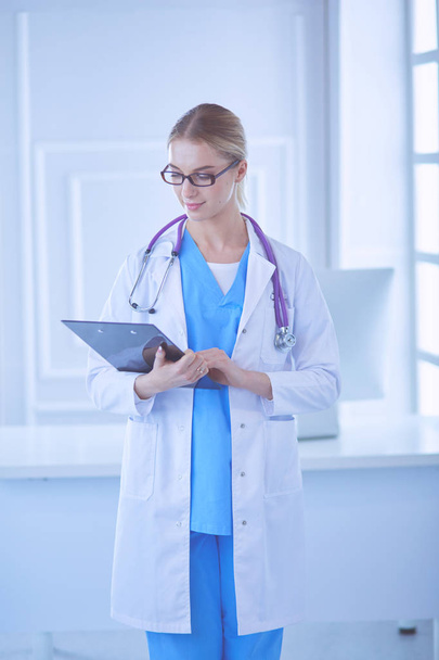 Smiling female doctor with a folder in uniform standing - Foto, imagen