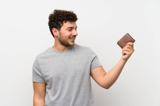 Hombre con pelo rizado sobre pared aislada sosteniendo una billetera
 - Foto, Imagen