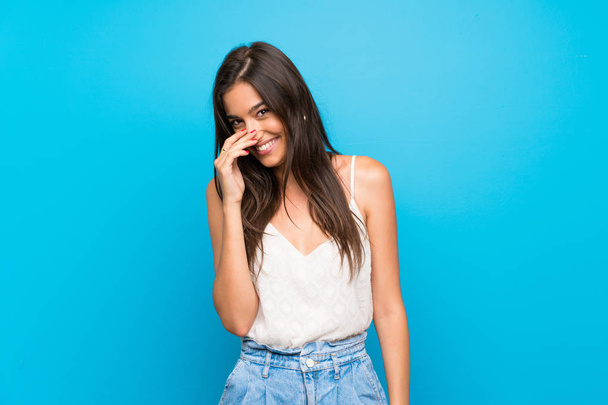 Young woman over isolated blue background smiling a lot - Φωτογραφία, εικόνα