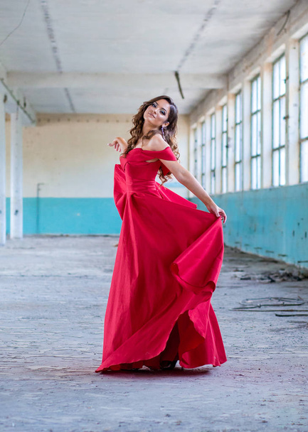 Beautiful teen girl in long, glamorous red dress going to her prom or dance - Foto, afbeelding