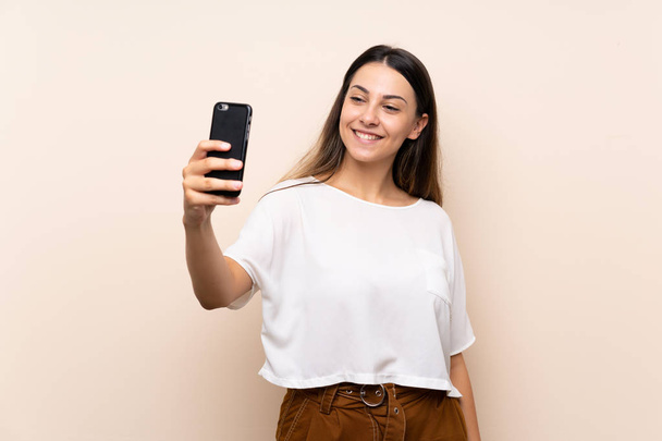 Jeune femme brune sur fond isolé faisant un selfie
 - Photo, image
