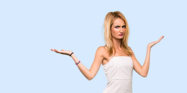Young blonde woman unhappy for not understand something over isolated blue background - Photo, Image