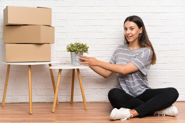 Mujer joven moviéndose en un nuevo hogar entre cajas
 - Foto, Imagen
