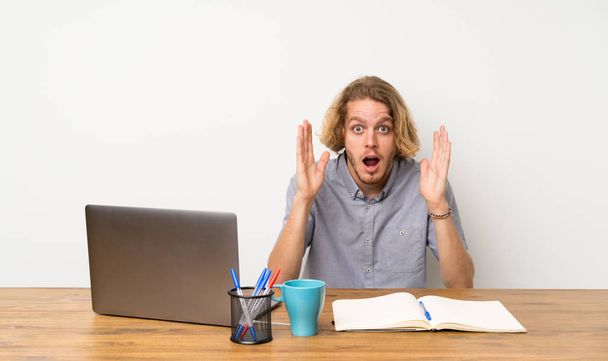 Blond człowiek z laptopem z wstrząśnięty wyraz twarzy - Zdjęcie, obraz