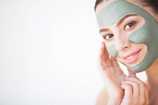 Soins de la peau. Jeune femme avec masque d'argile cosmétique tenant concombre à sa salle de bain
 - Photo, image