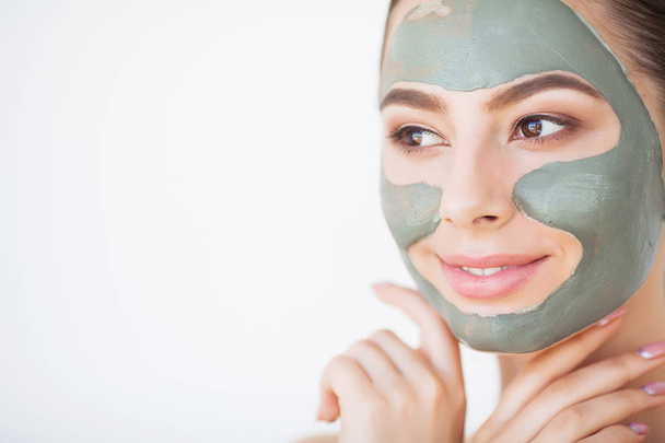 Skin Care. Young Woman With Cosmetic Clay Mask Holding Cucumber At Her Bathroom - Φωτογραφία, εικόνα