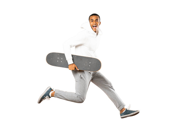 Full-length shot of Afro American skater man over isolated white background - 写真・画像