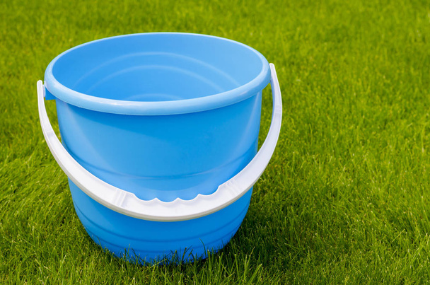 Barevné plastové zahradní kbelíky na pozadí zelené trávy - Fotografie, Obrázek