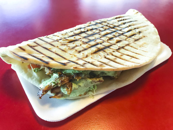 Spicy turkish doner kebab filled with roasted meat, fresh salad  and garlic sauce in toasted tortilla. - Фото, зображення