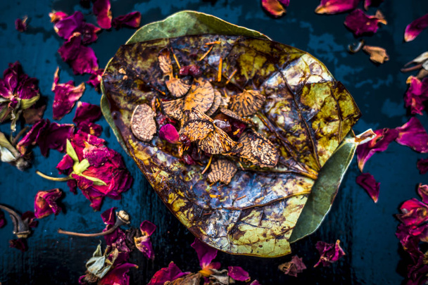 Close up of famous Indian traditional pan masala on dark surface with rose petals and sweeteners with coconut powder   - Foto, afbeelding