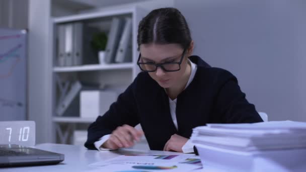 Female bank worker comparing data in graphs, satisfied with results, success - Imágenes, Vídeo