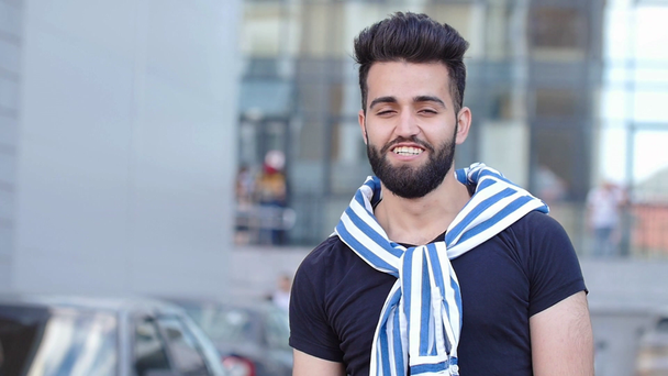 junger stilvoll lächelnder arabischer oder lateinischer junger Mann auf einer Straße in der Stadt - Filmmaterial, Video