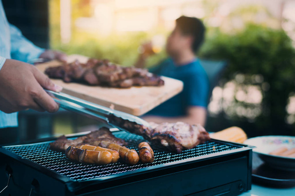 Close up asian hand man are pinching the pork on the grill and h - 写真・画像