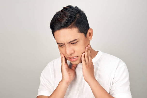 Портрет азіатських чоловіків з хвилюючі очі використовувати боку торкаючись його щоки, почуття болю від зубного болю. Концепція хвороби зубів і рота. - Фото, зображення