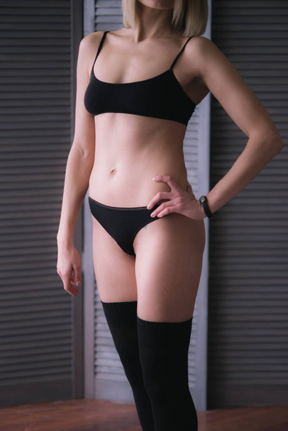 Attractive girl in lingerie. Girl in black lingerie.Beautiful female legs in lingerie - Фото, зображення