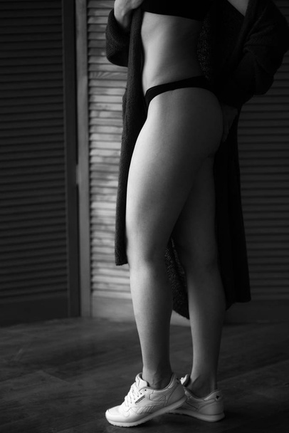 Attractive girl in lingerie. Girl in black lingerie.Beautiful female legs in lingerie - Fotó, kép