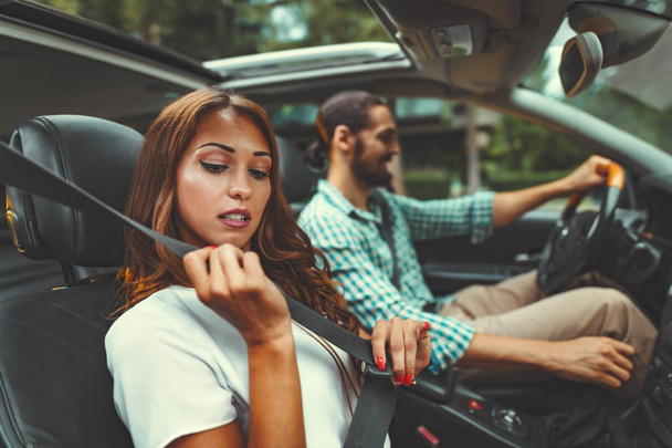 Jeune homme conduisant une voiture avec jeune femme sur le siège passager
  - Photo, image